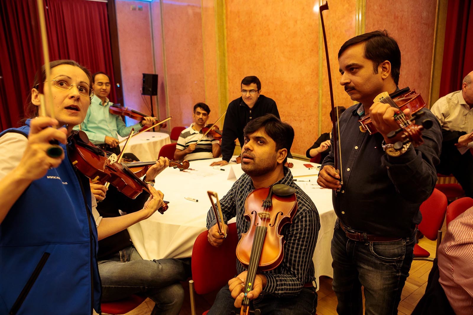 Zkusena instruktorka hry na housle vysvetluje budoucim muzikantum princip hry Crescendo
