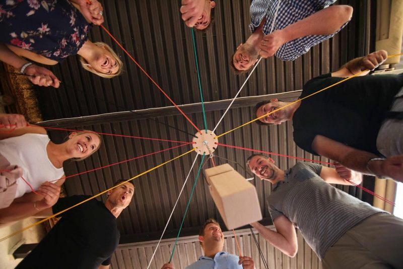 Tým účastníků při spolupracující teambuildingové hře Integrity