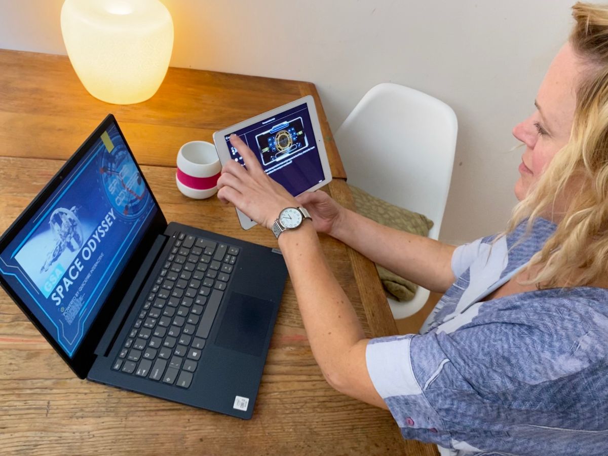 Woman plays Space Odyssey Online Teambuilding Game at Home with her Tablet
