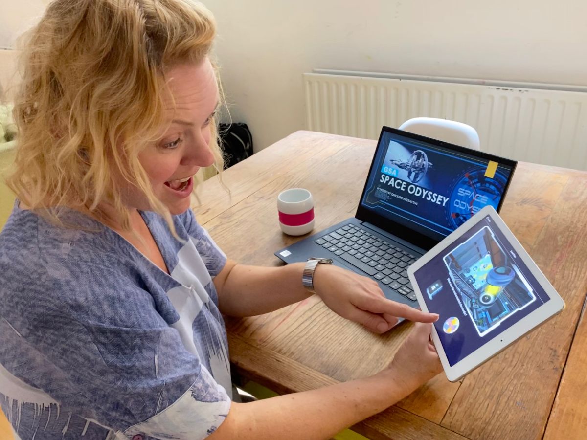 Woman plays Space Odyssey Online Teambuilding Game at Home